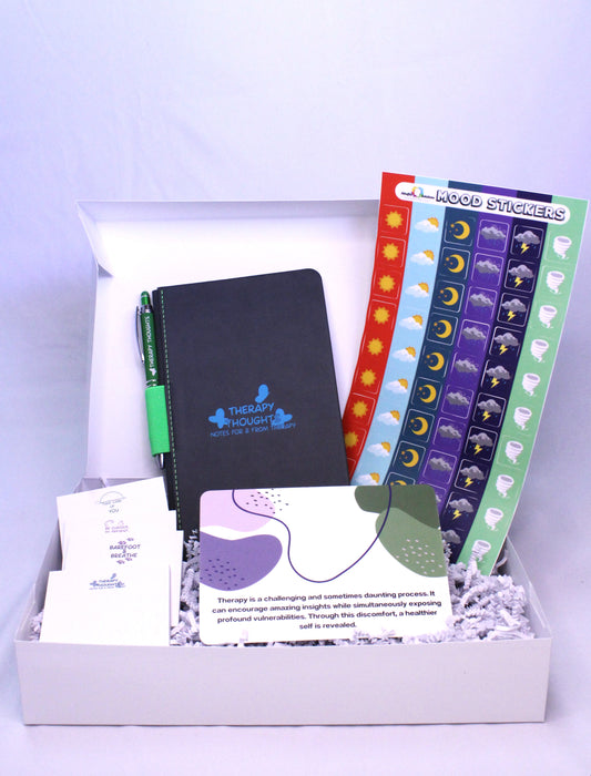 white box containing therapy journal, mood stickers, notepads, postcard